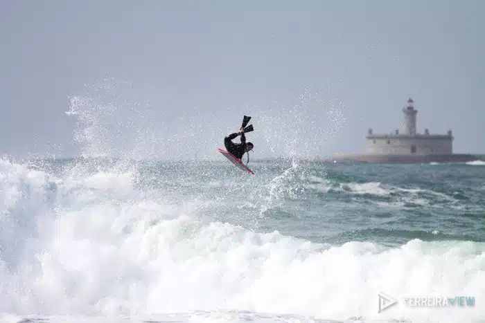 Rui Ferreira num aéreo de bodyboard, com o farol do Bugio ao fundo