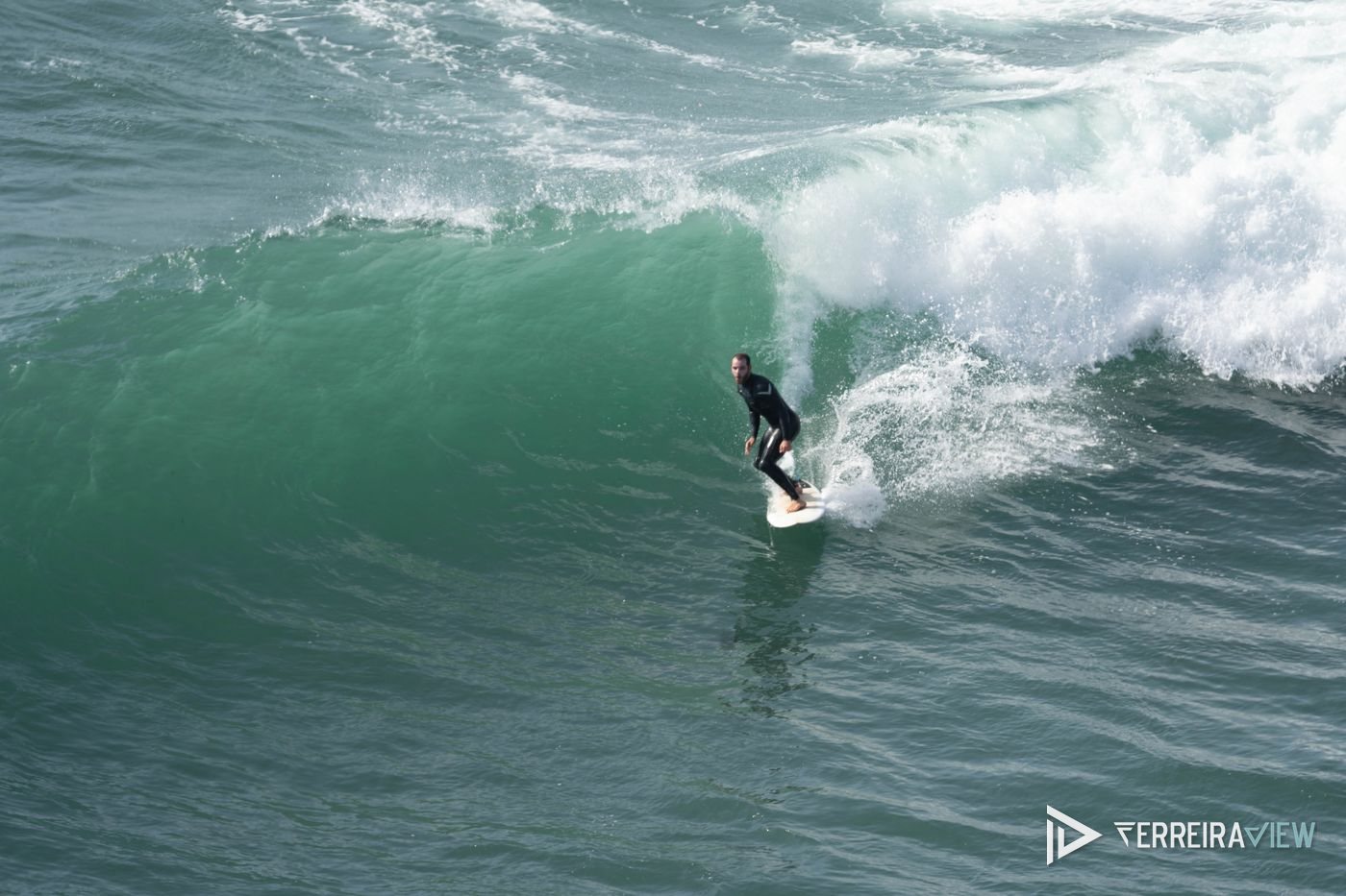 Surfista a descer a parede de uma onda na Ericeira, Portugal